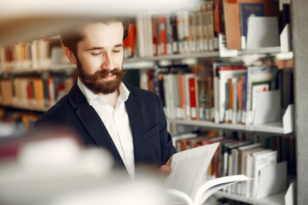 Guy reading in the library