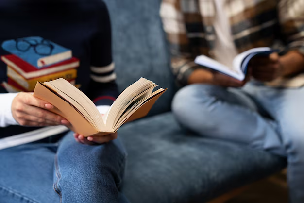 People reading books on the sofa, close-up view
