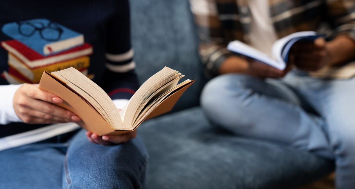 Close up of two person reading a book