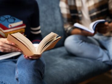 Close up of two person reading a book