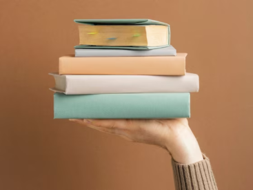 Hand holding a stack of books