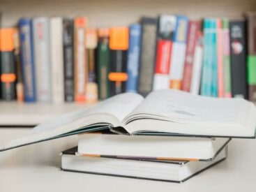 3 books lying on the table, one open