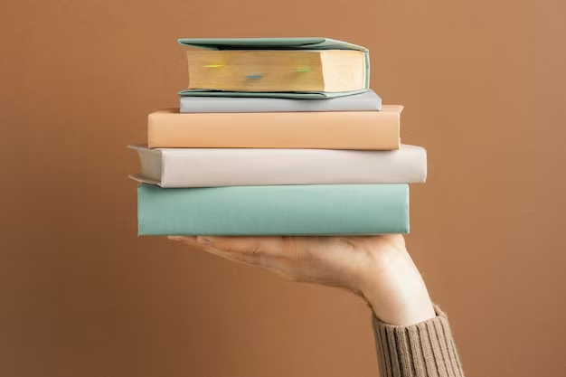 Hand holding a stack of books