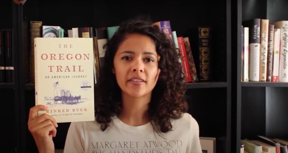 Girl holding book The Oregon Trail